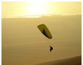 Acro world champion Raul Rodrigez paragliding into a sunset at Palo Buque, Iquique, Chile