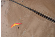 Paraglider aproaching a landing zone near the Rio Seco point, San Marcos, Iquique, Atacama Desert, Chile